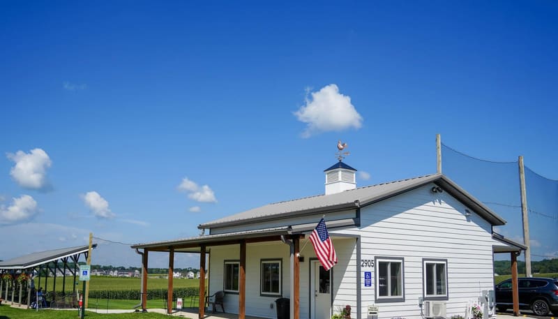 The finished all-new Verona Meadows clubhouse with white siding and a copper rooster weathervane